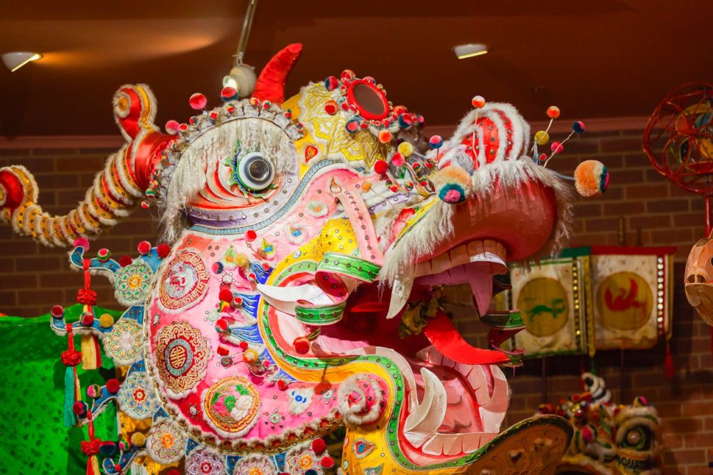 Colorful Chinese dragon dance costume on display indoors with intricate patterns.